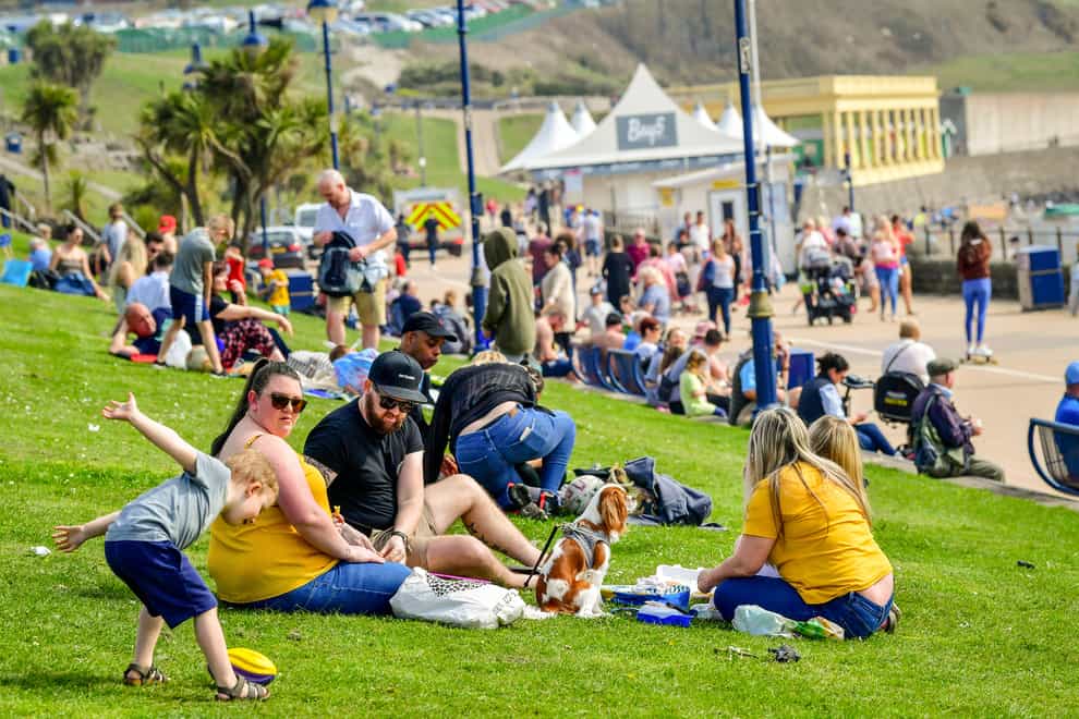 People relax on the grass at Barry Island, Wales