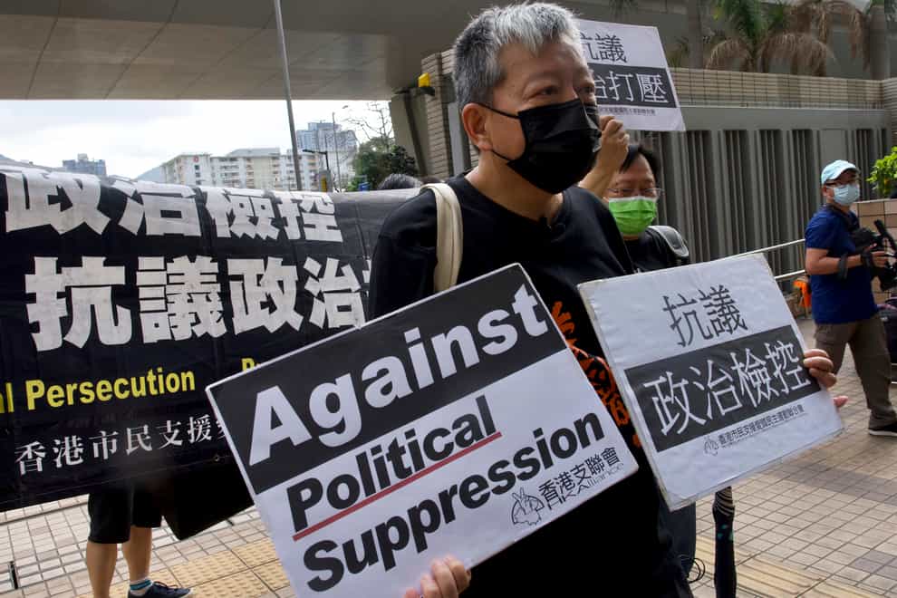 Pro-democracy activist Lee Cheuk-yan holds placards as he arrives at a court in Hong Kong
