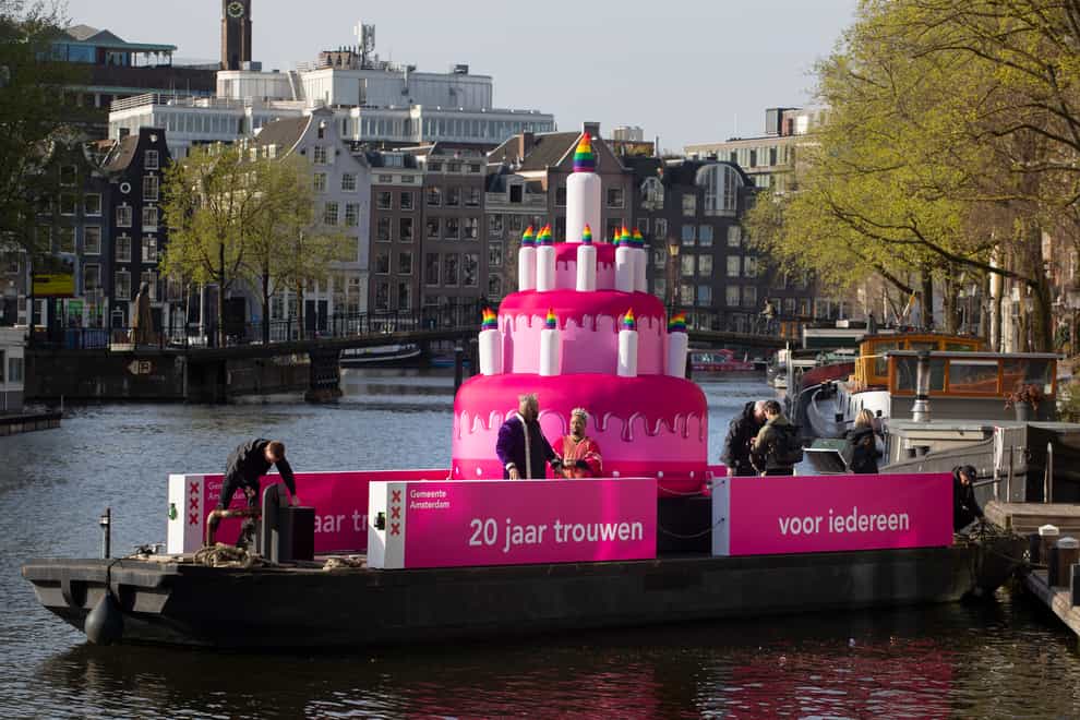 A huge inflatable pink cake with candles spouting rainbow flames glides through the Amsterdam canals as the Dutch capital celebrated the 20th anniversary of the world’s first legal same-sex marriages