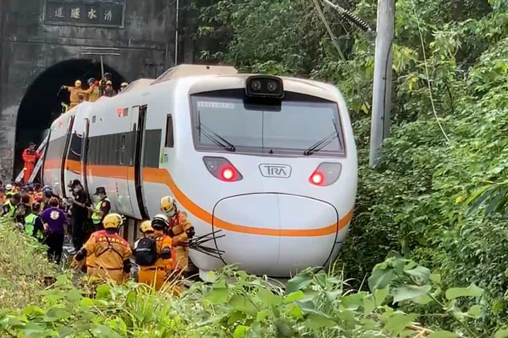Rescue workers gather near one end of the train (Executive Yuan via AP)
