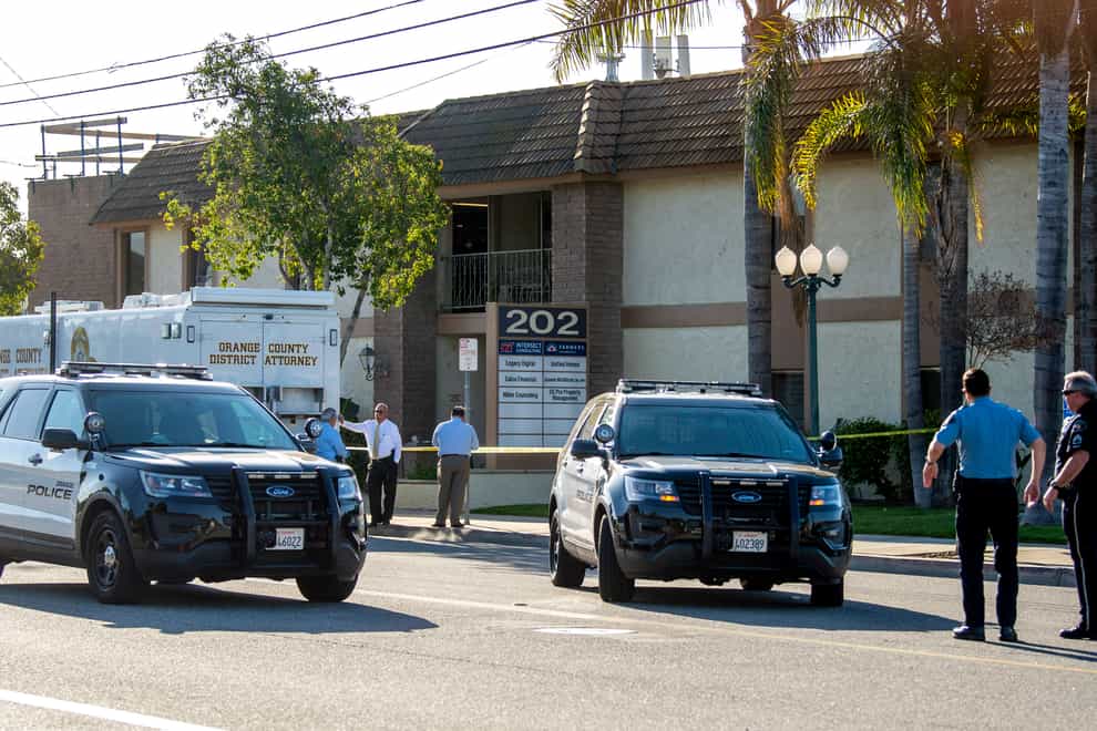 Officials work outside the scene of a shooting in Orange, California