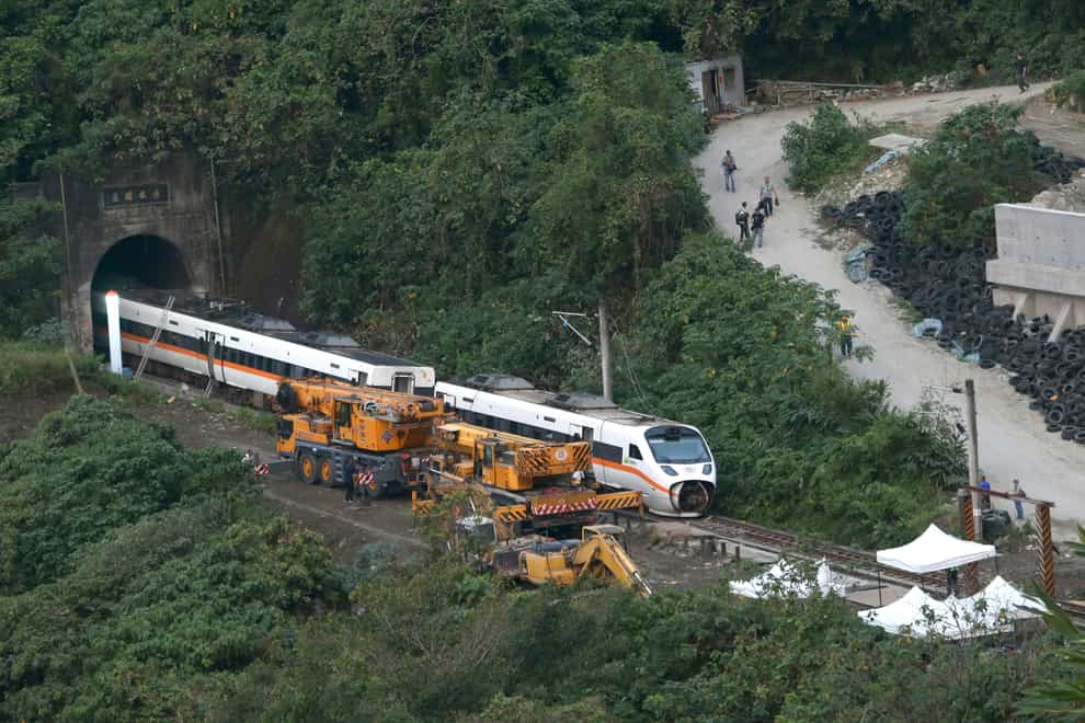 Rescue workers remove a part of the derailed train near Taroko Gorge in Hualien, Taiwan