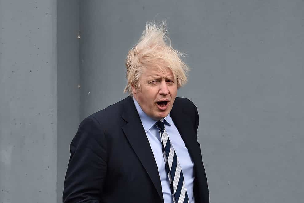 Boris Johnson's hair is blown up as he walks