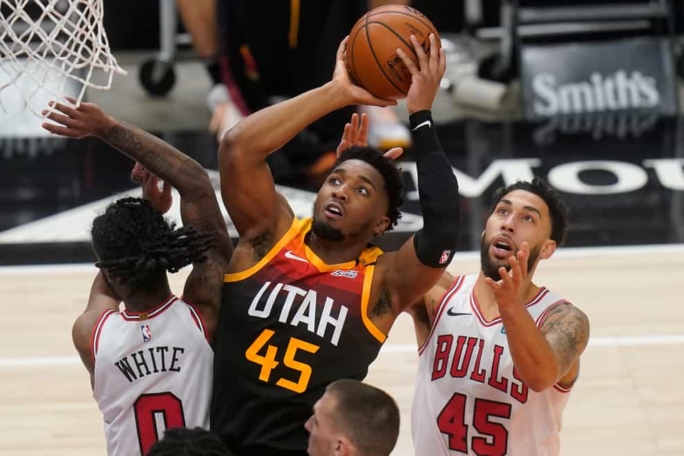 Utah Jazz guard Donovan Mitchell (45) goes to the basket as Chicago Bulls’ Coby White (0) and Denzel Valentine (45) defend