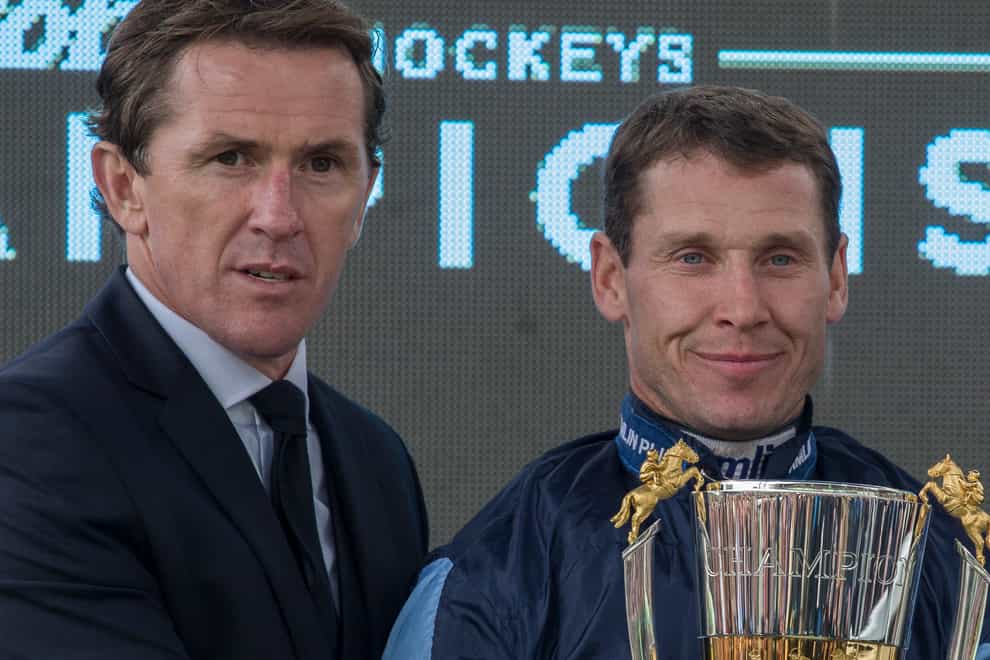 Richard Johnson is presented with the champion jump jockey trophy by Sir AP McCoy
