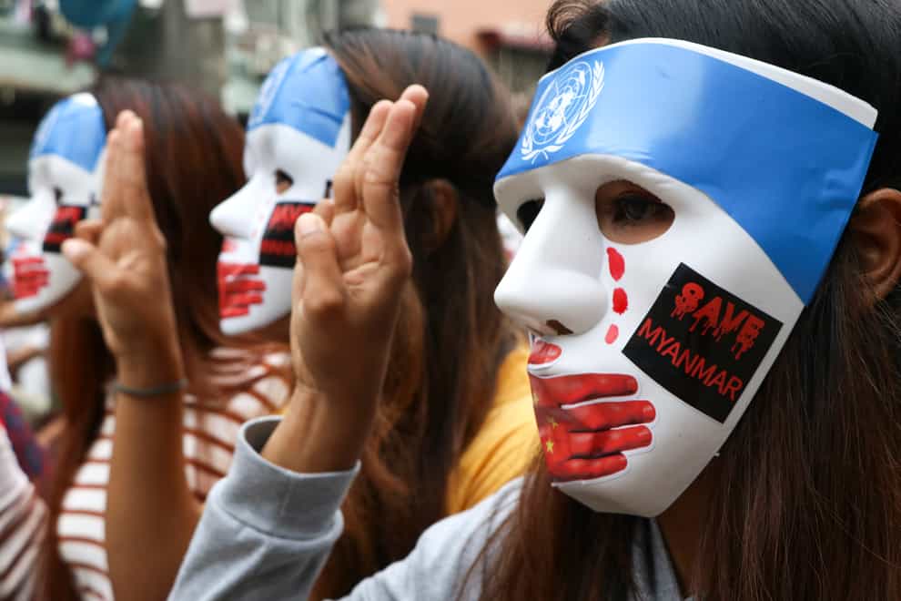 Young demonstrators flash the three-fingered symbol of resistance during an anti-coup mask strike in Yangon (AP)