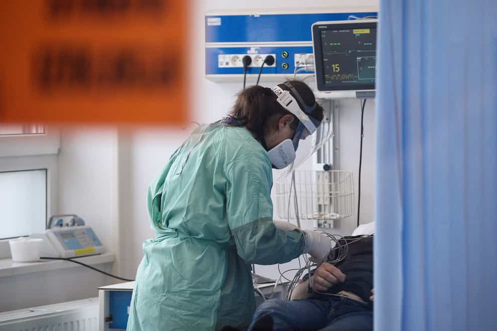 A medical worker attends to a Covid-19 patient in Poland