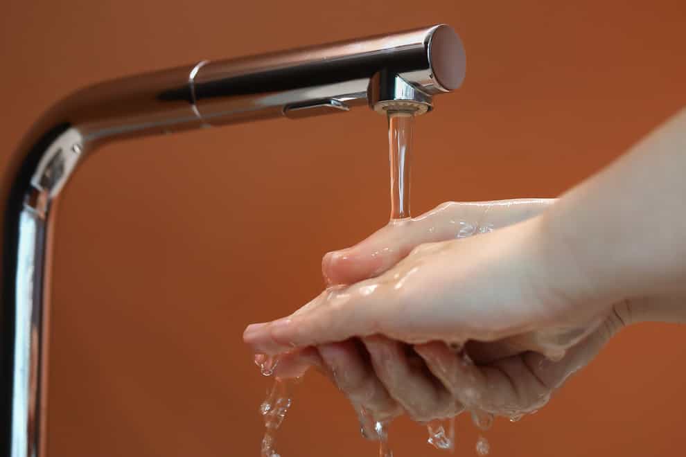 A person washes their hands under a tap