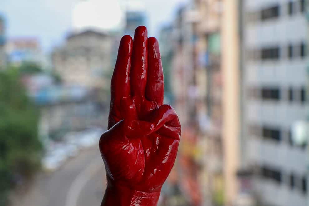 An anti-coup protester shows the three fingered salute of resistance on his red painted hand in memory of protesters who lost their lives (AP)