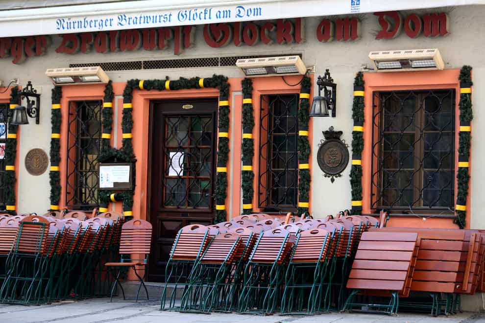 Chairs and tables outside a traditional Bavarian restaurant are locked at the city centre in Munich, Germany (Matthias Schrader/AP)