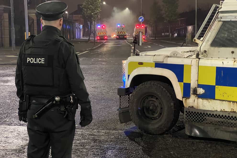 A PSNI officer stands on North Queen Street in Belfast looking towards Tigers Bay