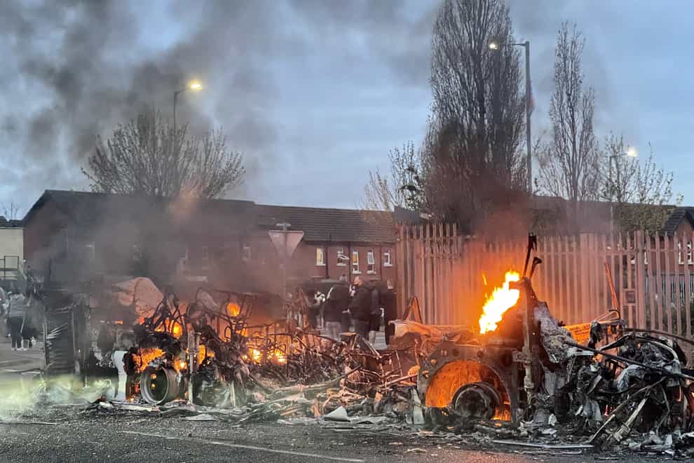 The wreckage of a Translink Metrobus on fire on the Shankill Road in Belfast