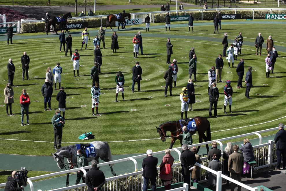Racegoers and riders observe a two-minute silence for the late Prince Philip at the Grand National Festival