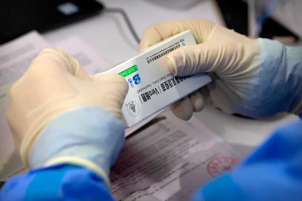A worker opens a package of coronavirus vaccine made by a Sinopharm subsidiary