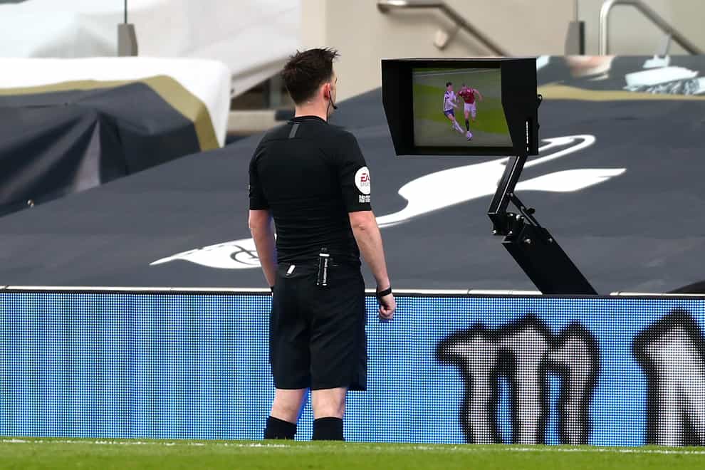 Referee Chris Kavanagh consults the pitchside monitor before ruling out Edinson Cavani's goal