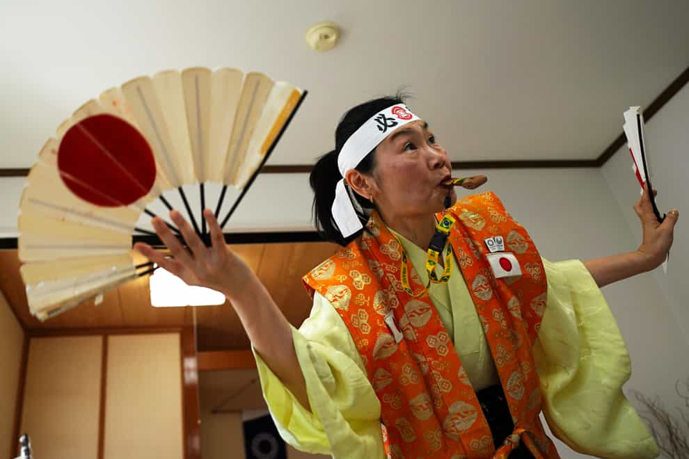 Olympic fan Kyoko Ishikawa shows her cheering at her home in Tokyo