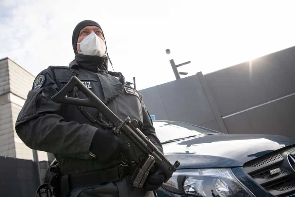 An armed court officer stands in front of an entrance to the grounds of the Higher Regional Court in Stuttgart-Stammheim, Germany
