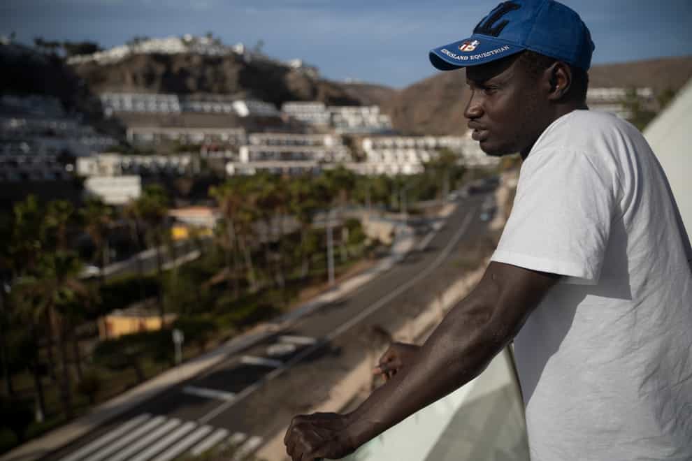 Senegalese migrant Fode Top looks at the view from the hotel room at Holiday Club Puerto Calma in Puerto Rico de Gran Canaria, Spain