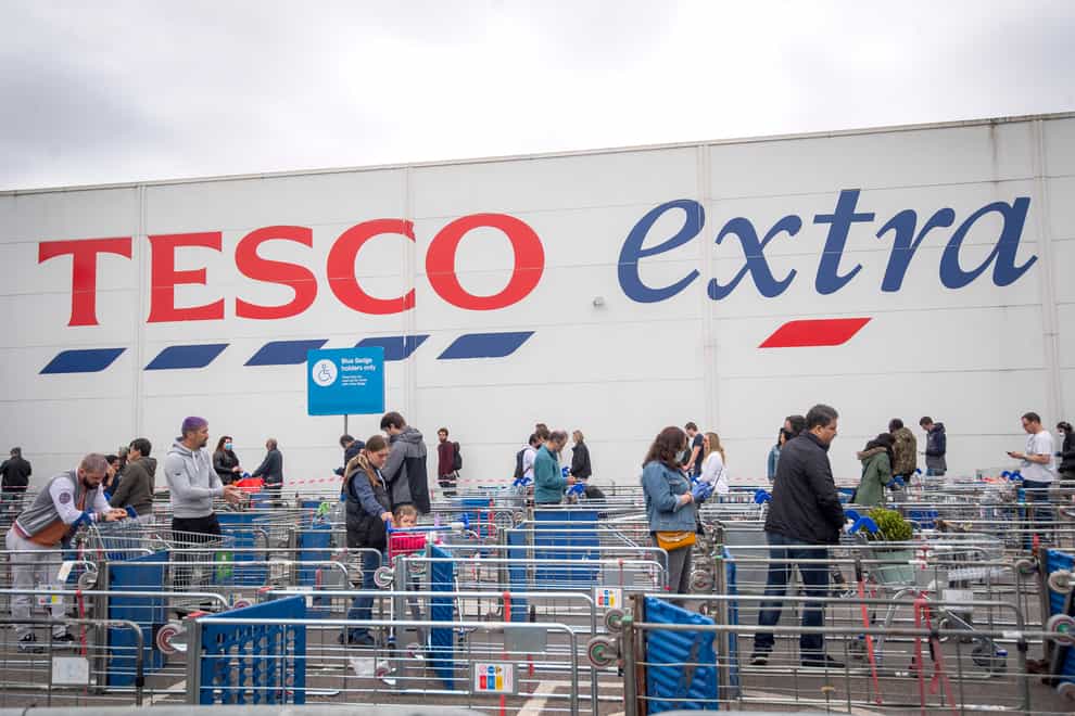 Customers queue outside a Tesco Extra store