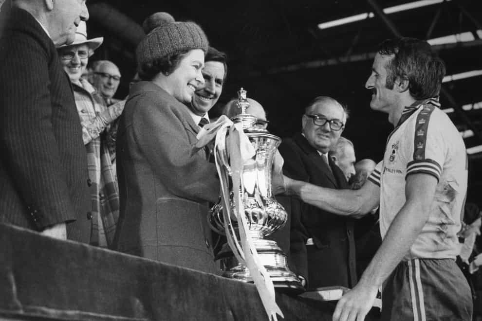 The Queen presents Southampton captain Peter Rodrigues with the FA Cup after the 1976 final at Wembley.