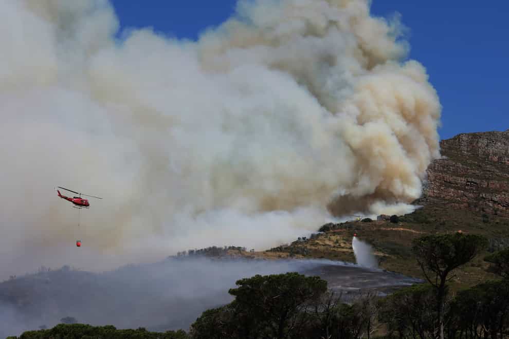 A helicopter drops water over a fire at Rhodes Memorial on Table Mountain, Cape Town (Nardus Engelbrecht/AP)