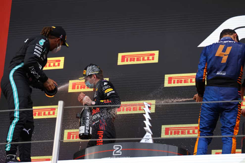 Lewis Hamilton, left, sprays race winner Max Verstappen with champagne on the podium