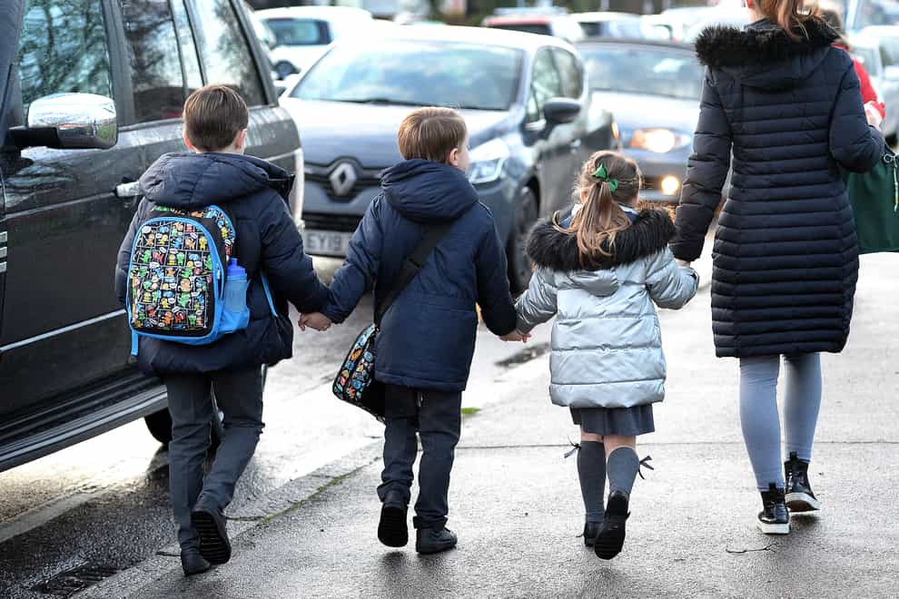 Children walking to school alongside traffic