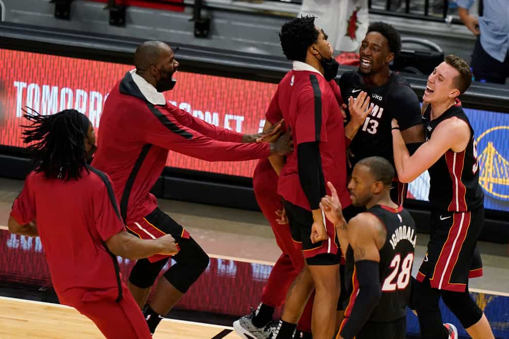 Miami Heat centre Bam Adebayo is mobbed by teammates after he made the winning shot against the Brooklyn Nets