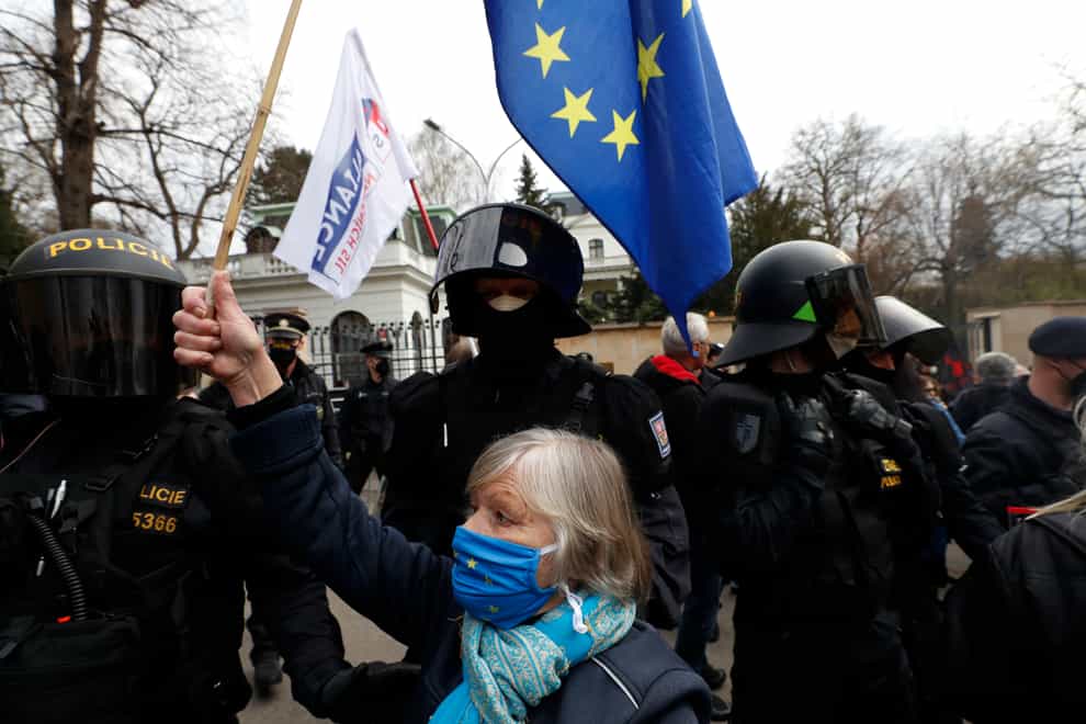 A woman waves a European Union flag in front of the Russian embassy in Prague, Czech Republic