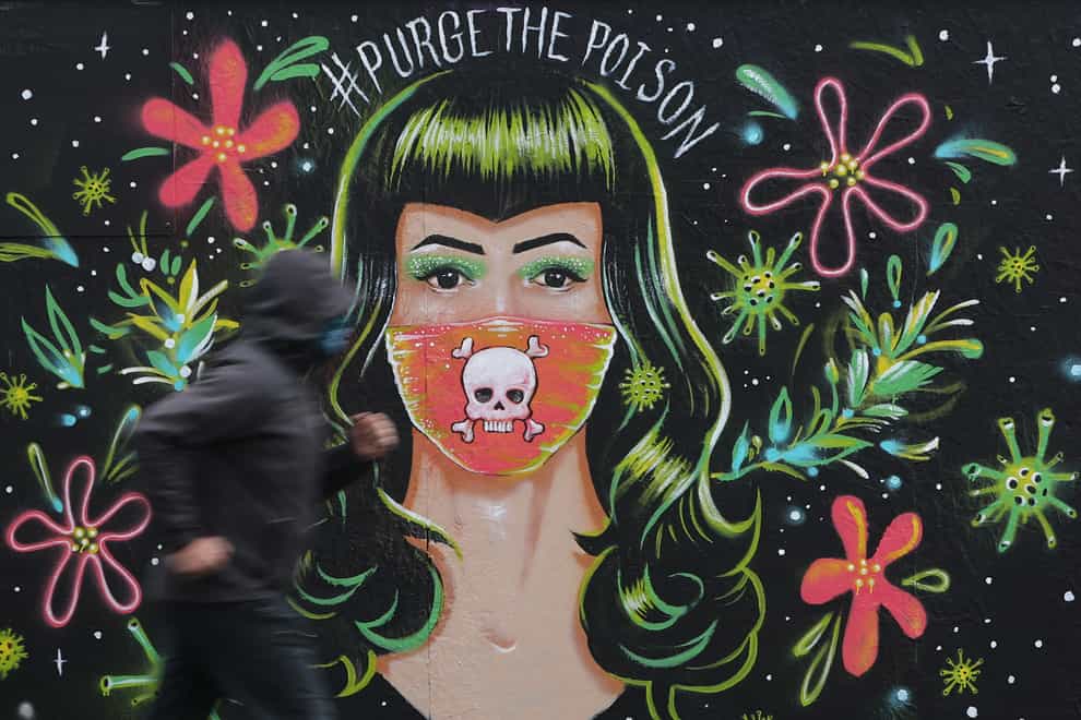 A jogger passes a mural by Brazilian artist Gabriel Marques in Dublin’s Grand Canal area, during Covid-19 lockdown (Niall Carson/PA)