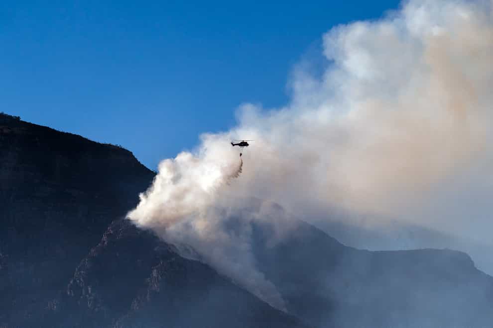 A South African military helicopter drops water on the top of Table Mountain in Cape Town