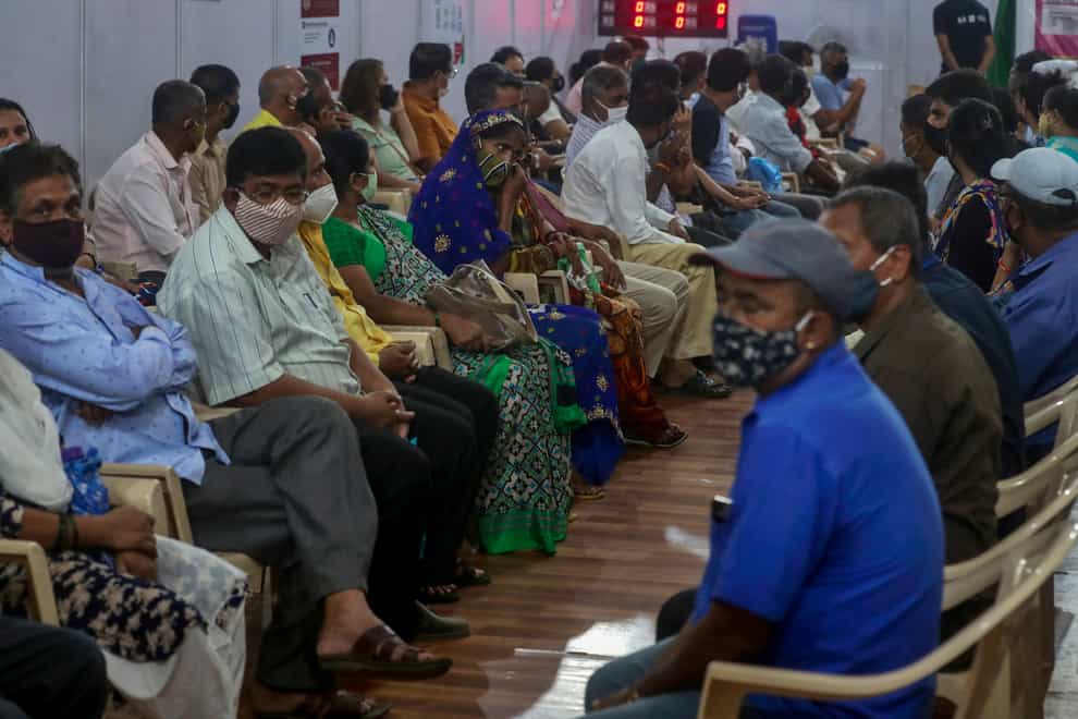 People wait to receive a vaccine in Mumbai, India