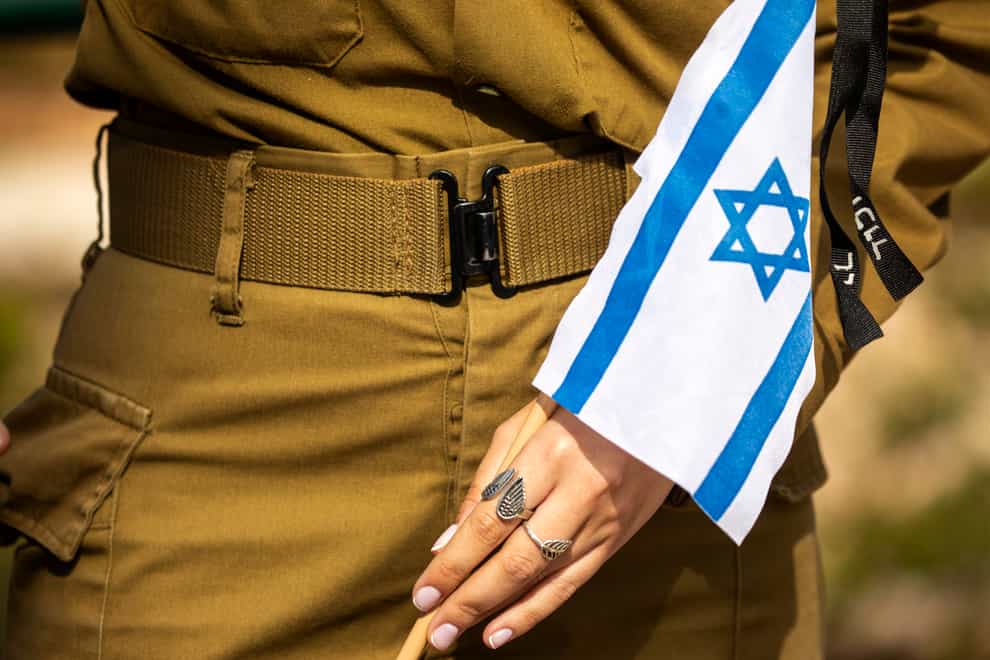 A soldier holding an Israeli flag