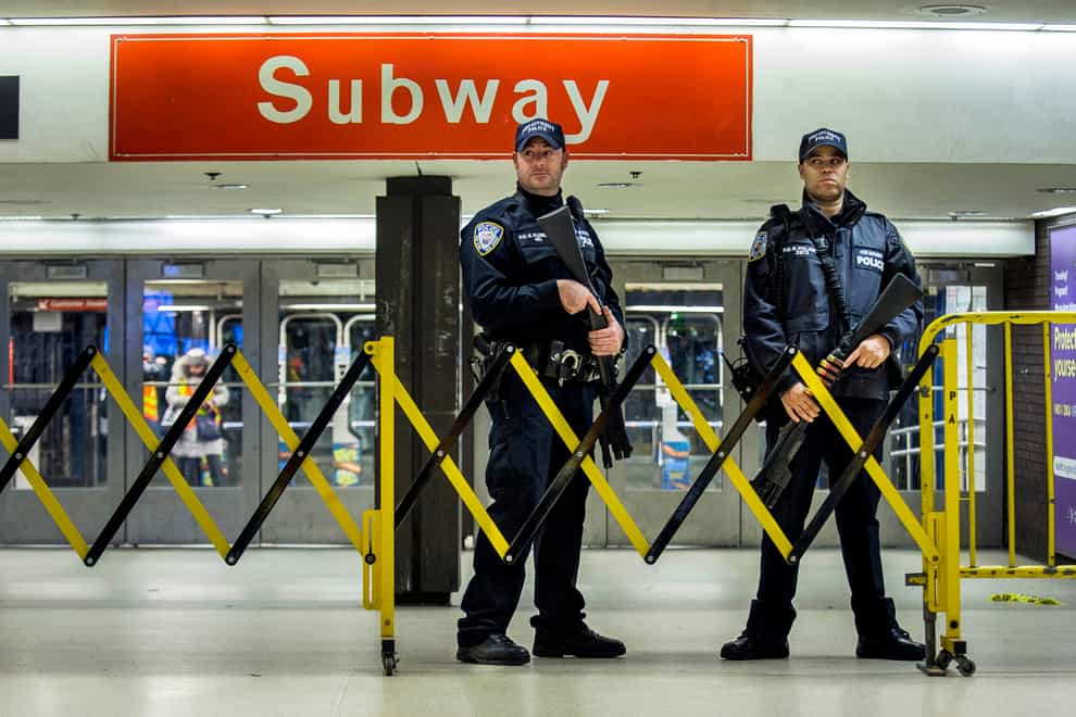 Police stand guard inside the Port Authority Bus Terminal following an explosion near Times Square in New York in 2017