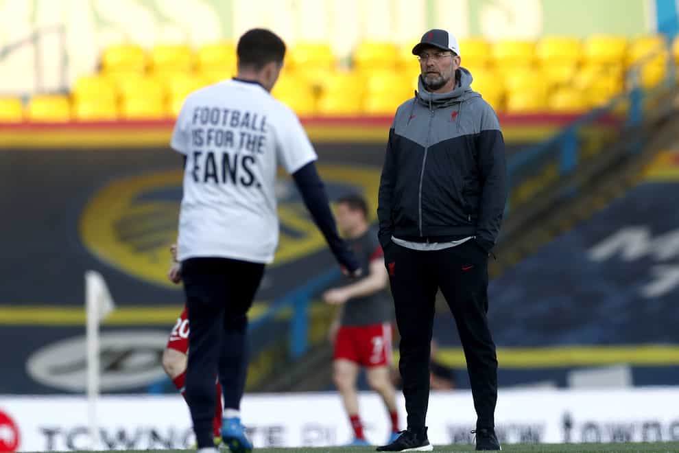 Liverpool manager Jurgen Klopp looks on as a Leeds United player warms up on the pitch wearing a shirt opposing the new Super League.