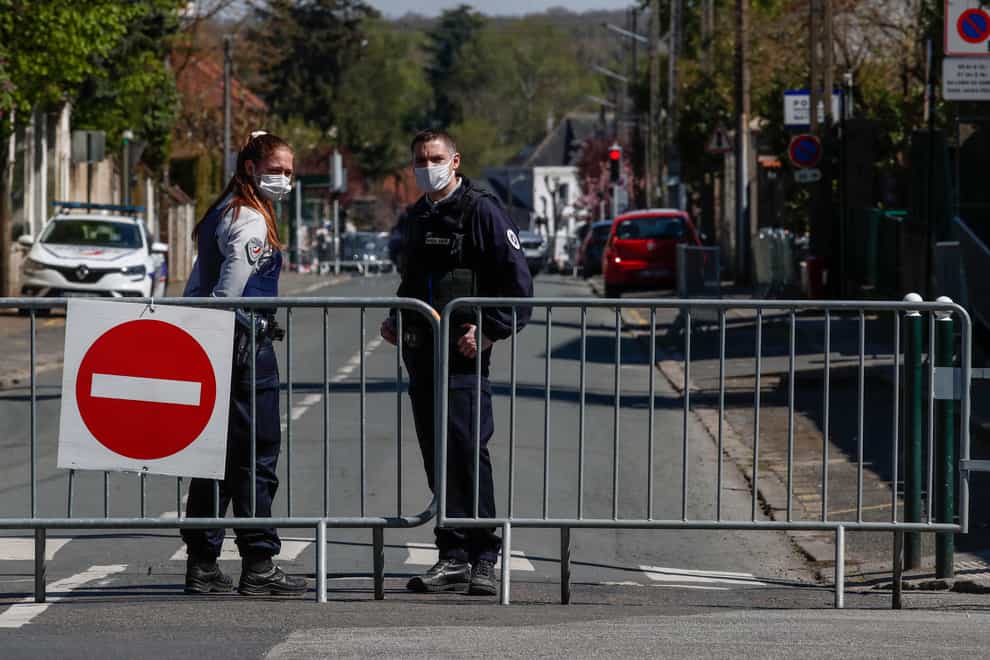 French police officers block the access next to the police station where a police official was stabbed to death Friday in Rambouillet, south-west of Paris