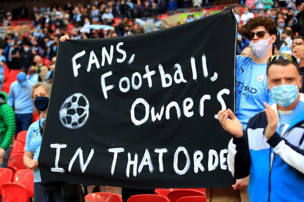 Fans hold up a banner protesting against the European Super League ahead of the Carabao Cup Final between Manchester City and Tottenham at Wembley