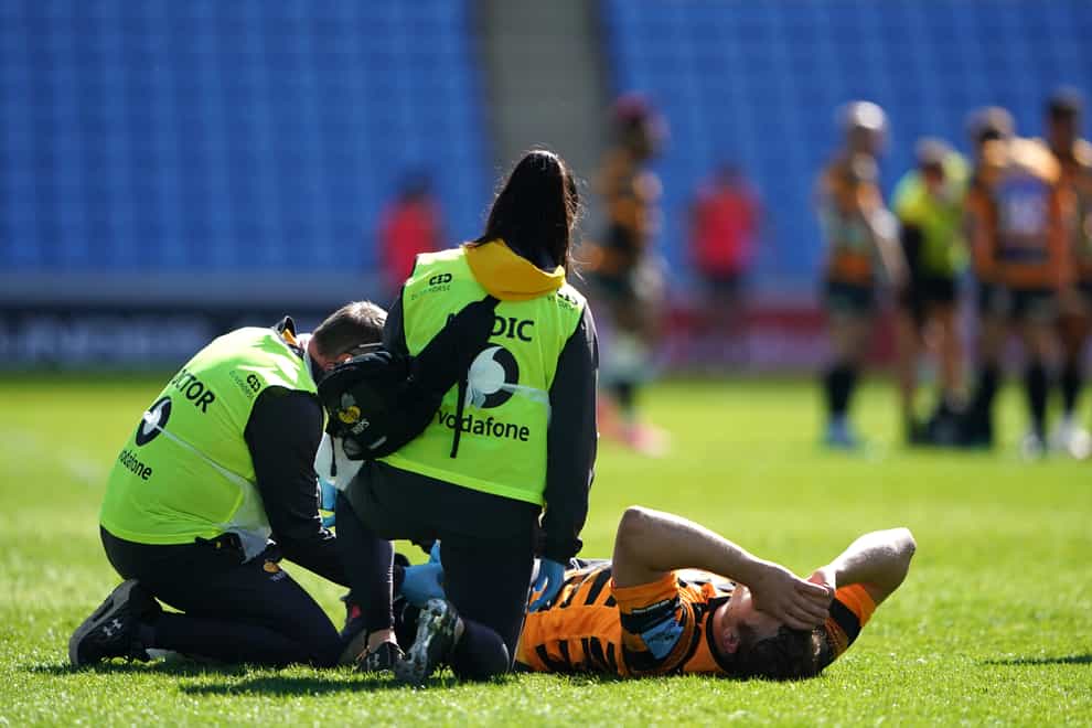 Joe Launchbury receives medical attention after taking a blow to his left knee