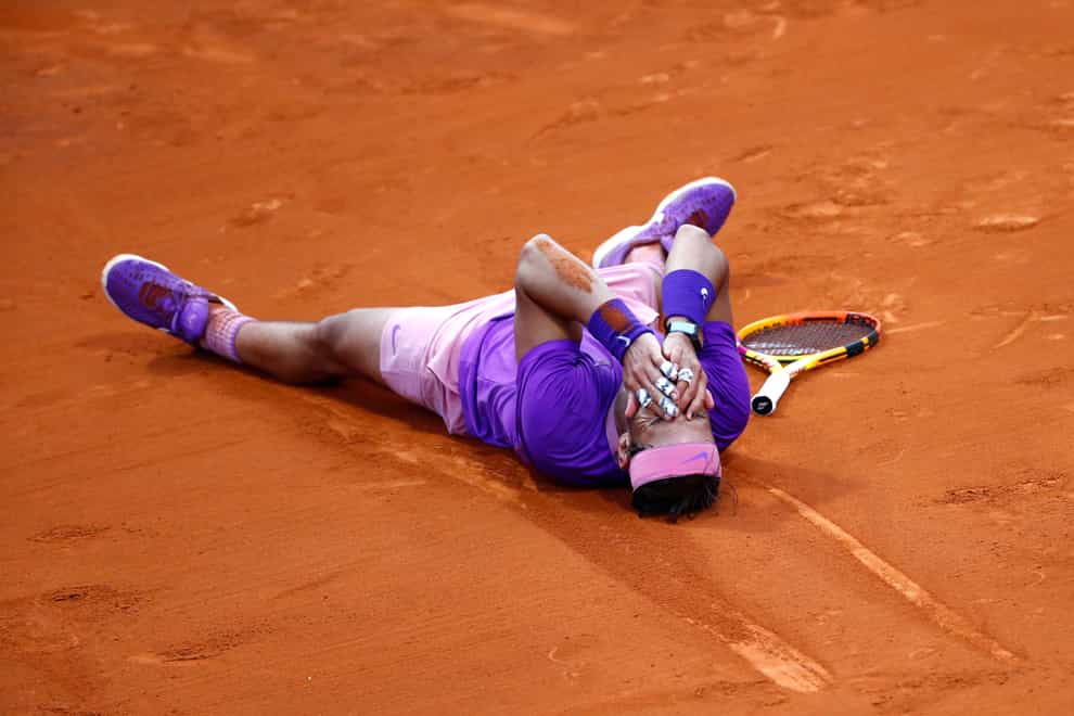 Rafael Nadal lies on the clay after his epic victory over Stefanos Tsitsipas