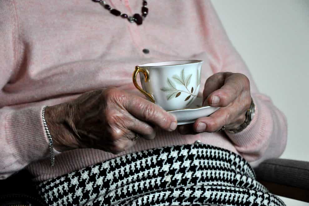 Elderly woman holding a cup of tea