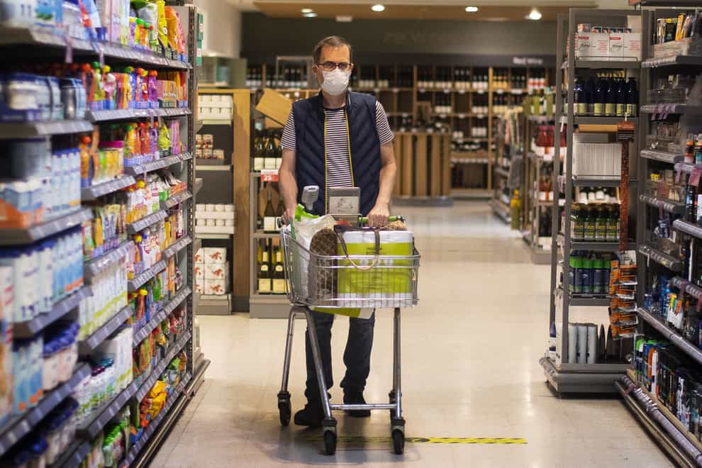 A shopper pushes a trolley in a supermarket