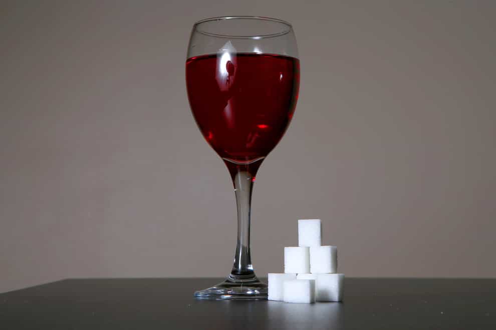 A glass of wine and some sugar cubes