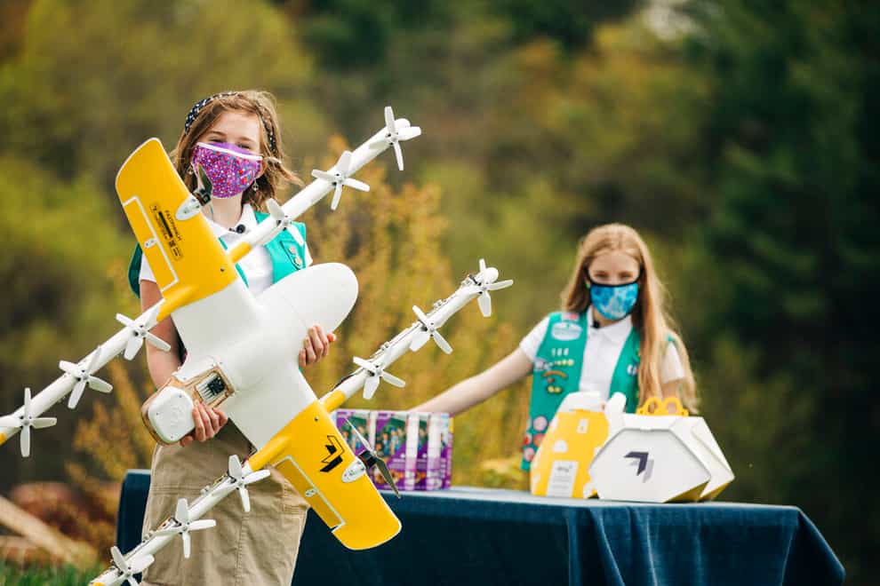 Girl Scouts Alice Goerlich and Gracie Walker pose with a Wing delivery drone