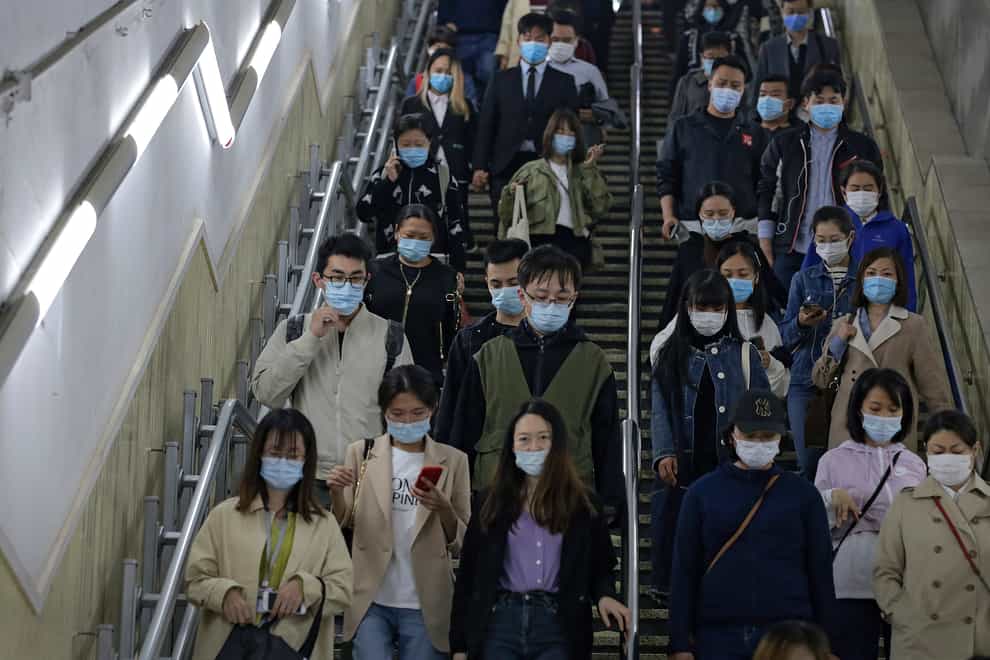 People on an escalator in Beijing (Andy Wong/AP)