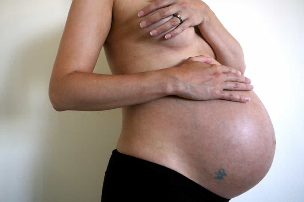 A pregnant woman cradles her bump