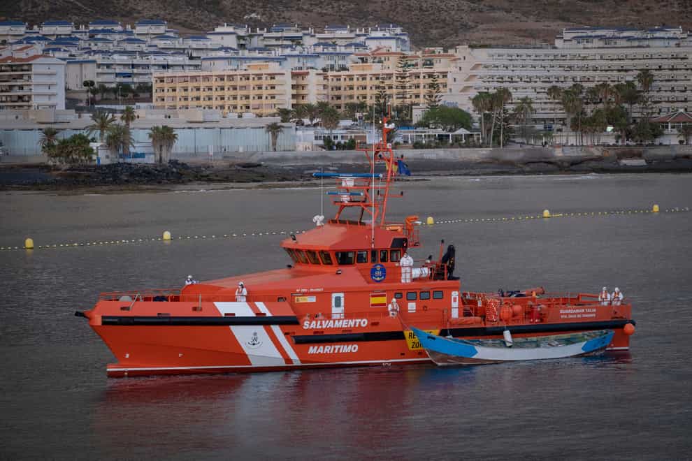 A wooden boat is towed by a Spanish Maritime Rescue Service ship