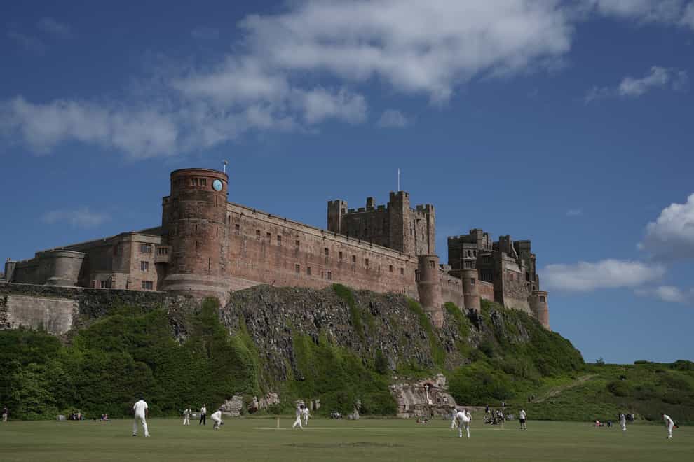 <p>Bamburgh’s imposing castle with its picturebook cricket pitch below</p>