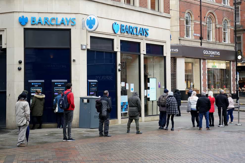 Customers queue outside a Barclays bank