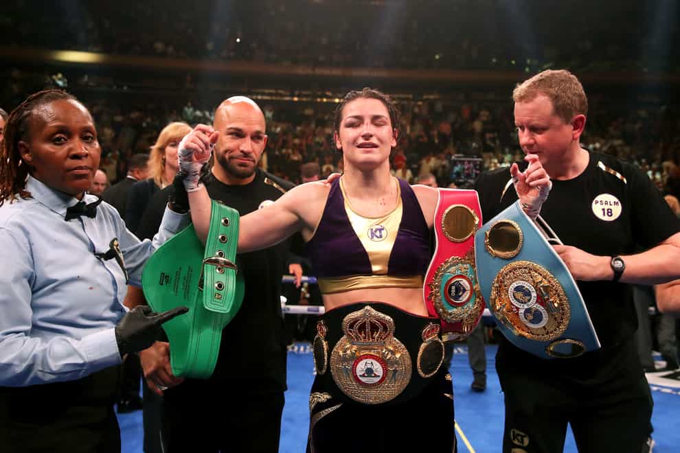 Katie Taylor (centre) holds her belts
