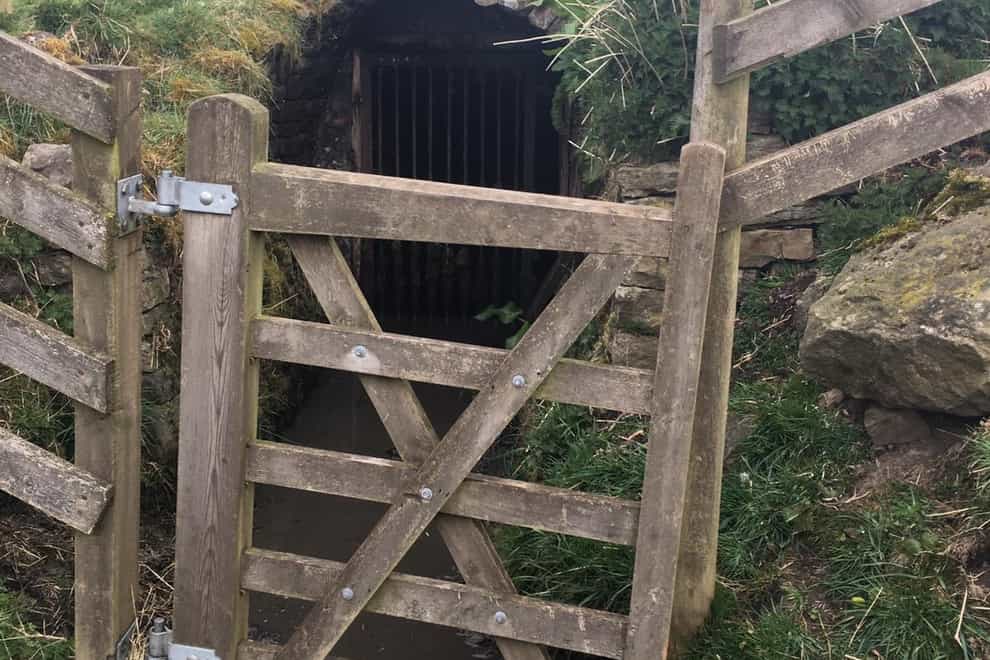 Entrance to a disused mine with timber gate in front